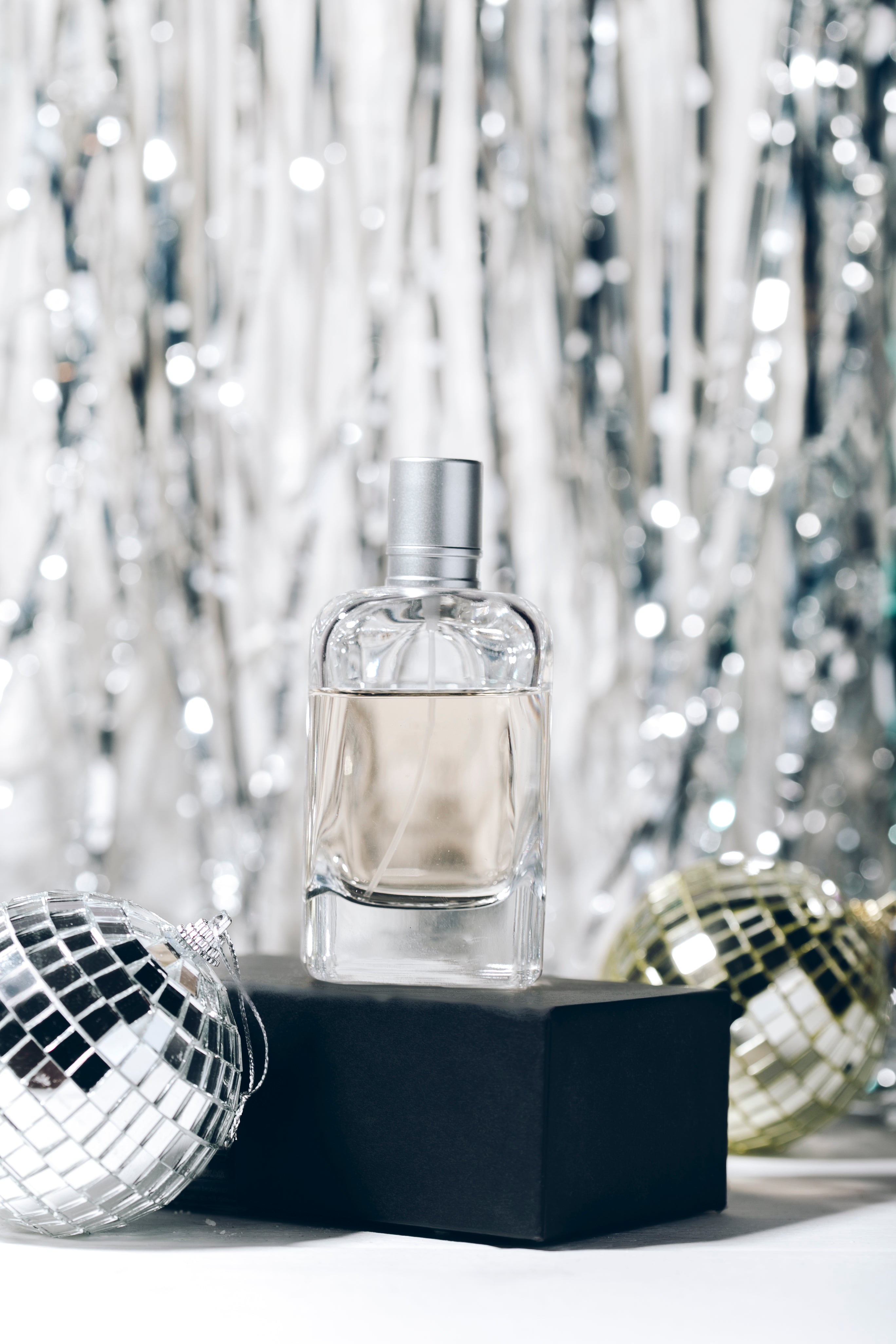 Flacon de parfum d’ambiance élégant sur fond festif argenté – création raffinée Clémentine Humeau, senteur pour la maison.