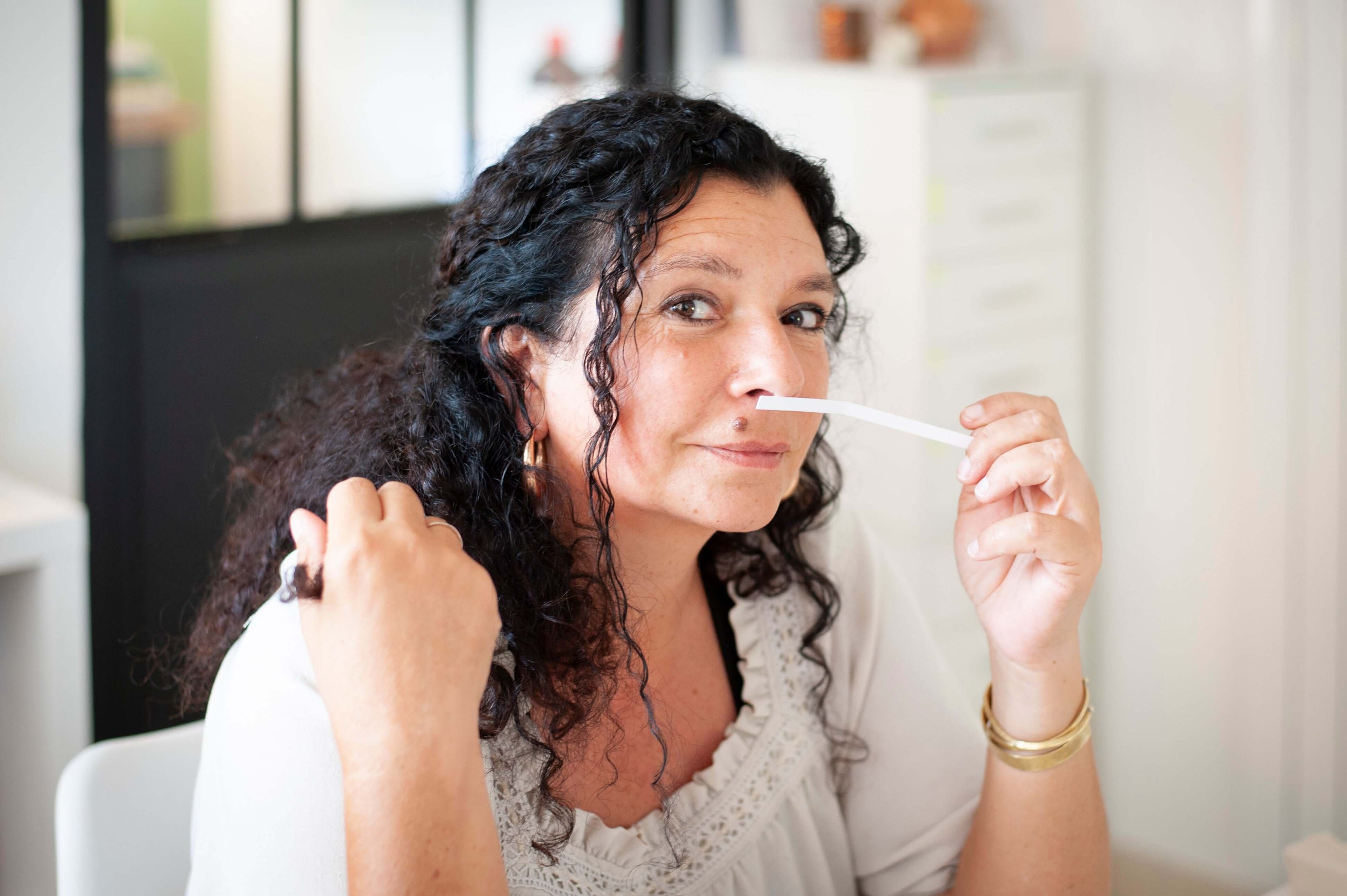 Clémentine Humeau dans son laboratoire en train de sentir une touche à parfum